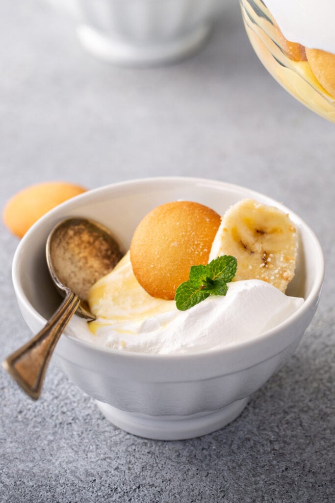 Bagatelle au pudding aux bananes avec des gaufrettes à la vanille et une tranche de banane dans un petit bol