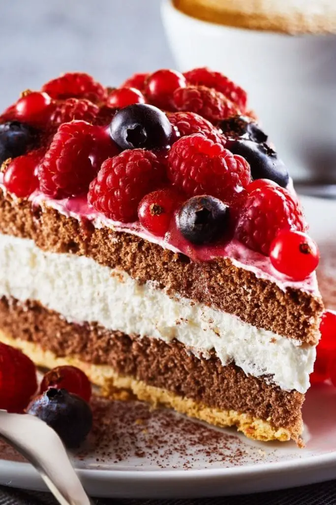 Idéias de recheio de torta (+ Receitas fáceis) com uma fatia de torta de frutas vermelhas em camadas