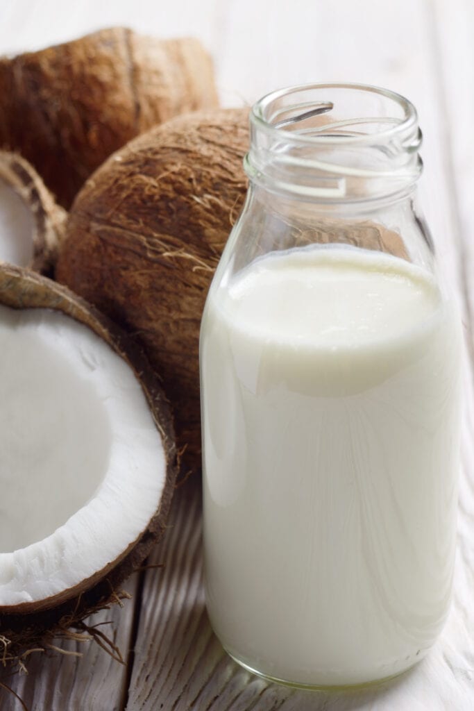 Färsk kokosmjölk i en genomskinlig flaska
