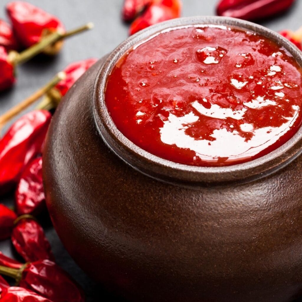 Ketchup en una pequeña olla marrón rodeada de cayena