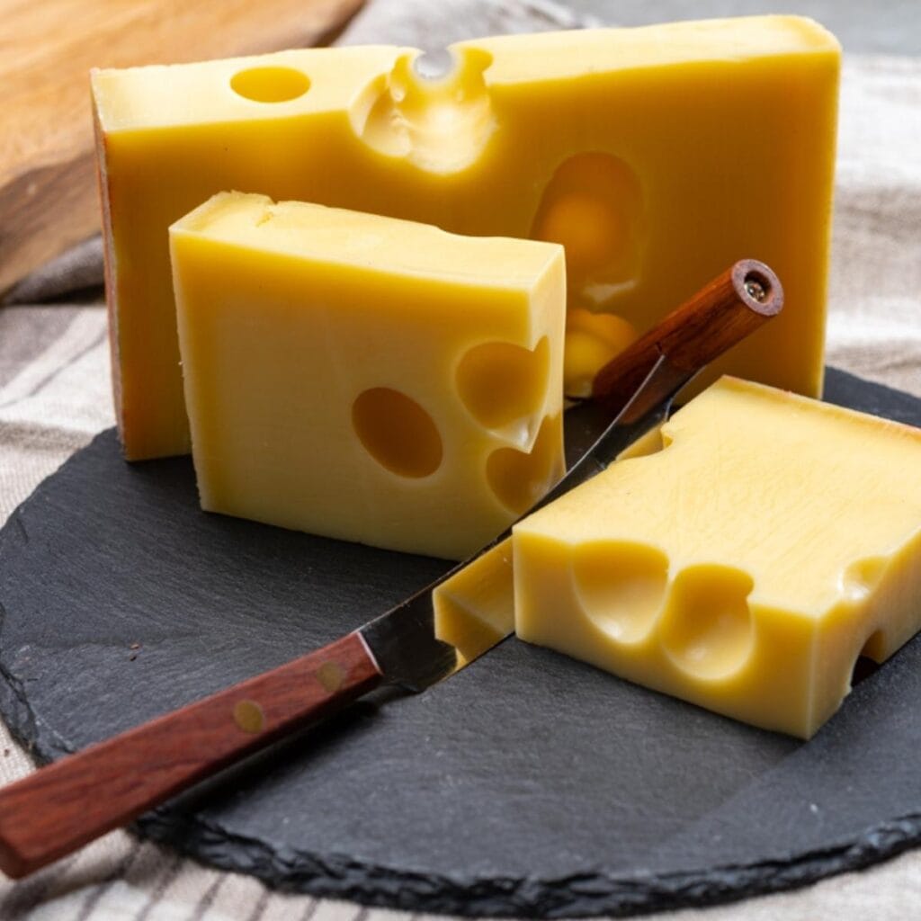 Rodajas De Queso Emmental En Una Tabla De Cortar Negra