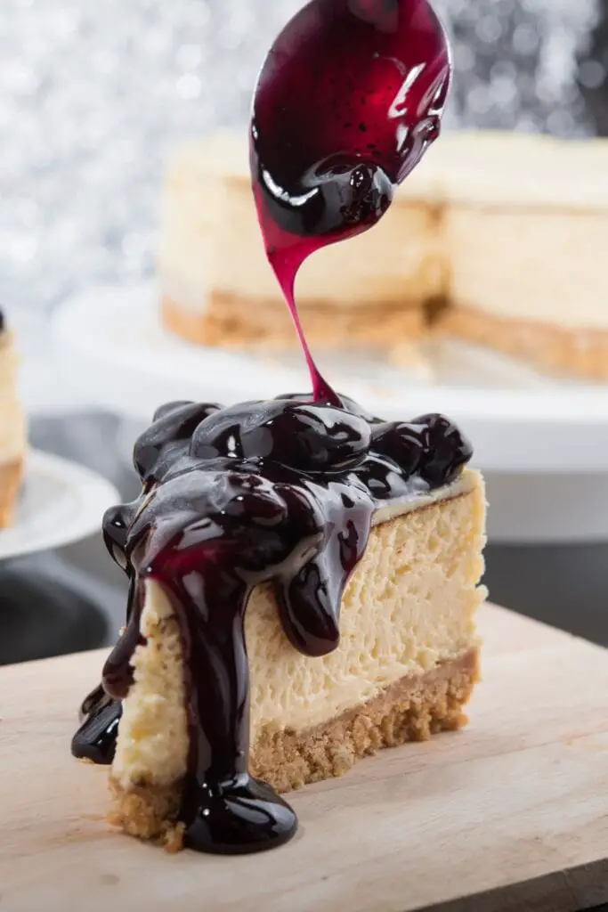 Una rebanada de pastel de queso con relleno de pastel de arándanos