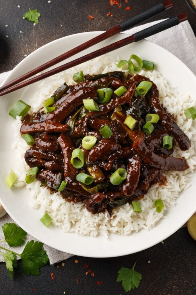 17 asiatiske oksekødsretter (hurtigt og nemt). Vist på billedet: Mongolsk oksekød med ris og grønne løg