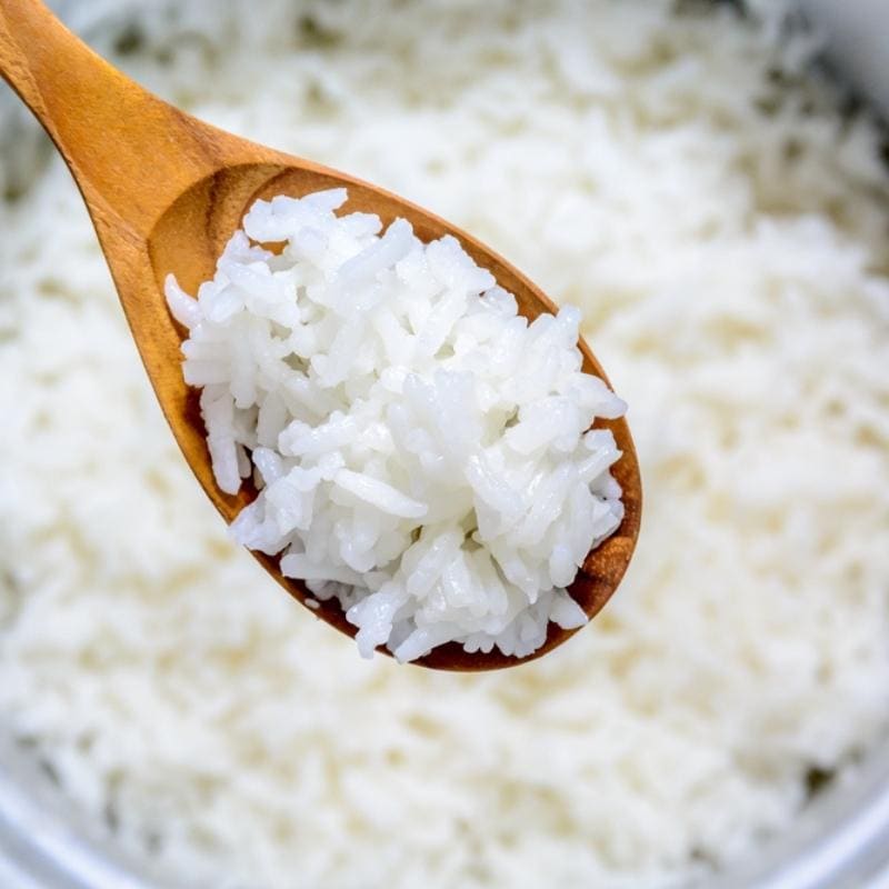 Cómo recalentar el arroz sobrante (3 formas simples): arroz blanco cocido con una cuchara de madera