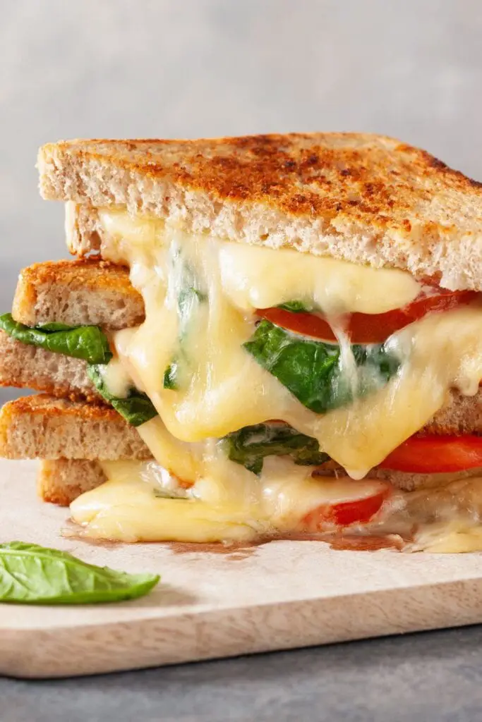 烤奶酪三明治，木板上放著西紅柿
