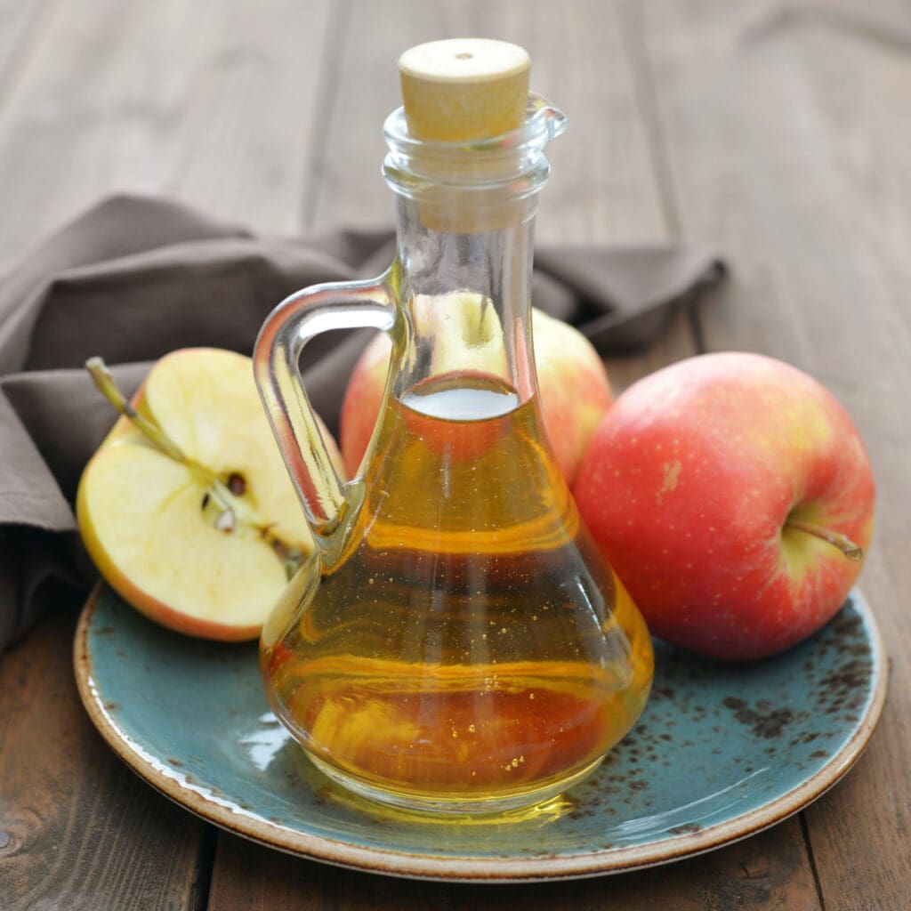 Manzanas frescas y vinagre de sidra de manzana en una botella