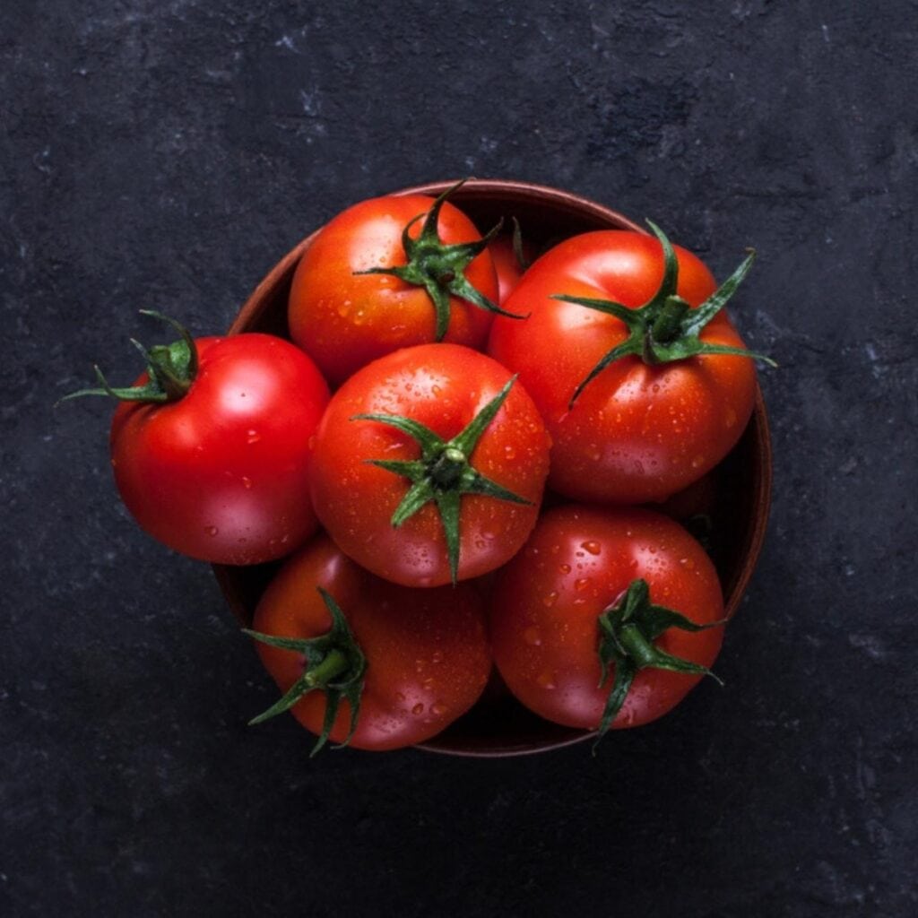 Świeże czerwone pomidory w brązowej misce