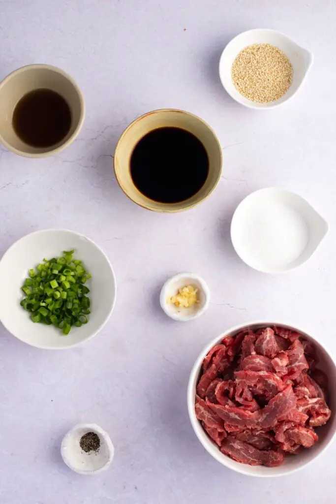 Ingredientes de carne de res Bulgogi: bistec, salsa de soya, azúcar, cebollas verdes, ajo, semillas de sésamo y pimienta