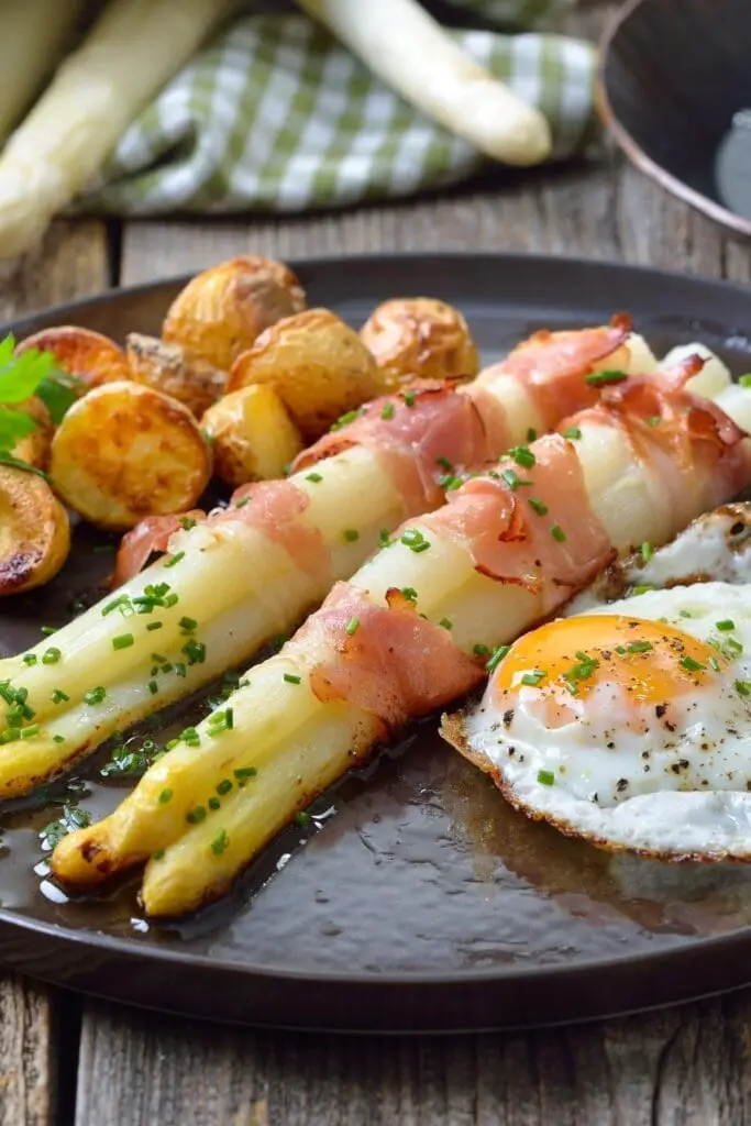 Bagte hvide asparges pakket ind i bacon med kartofler og æg