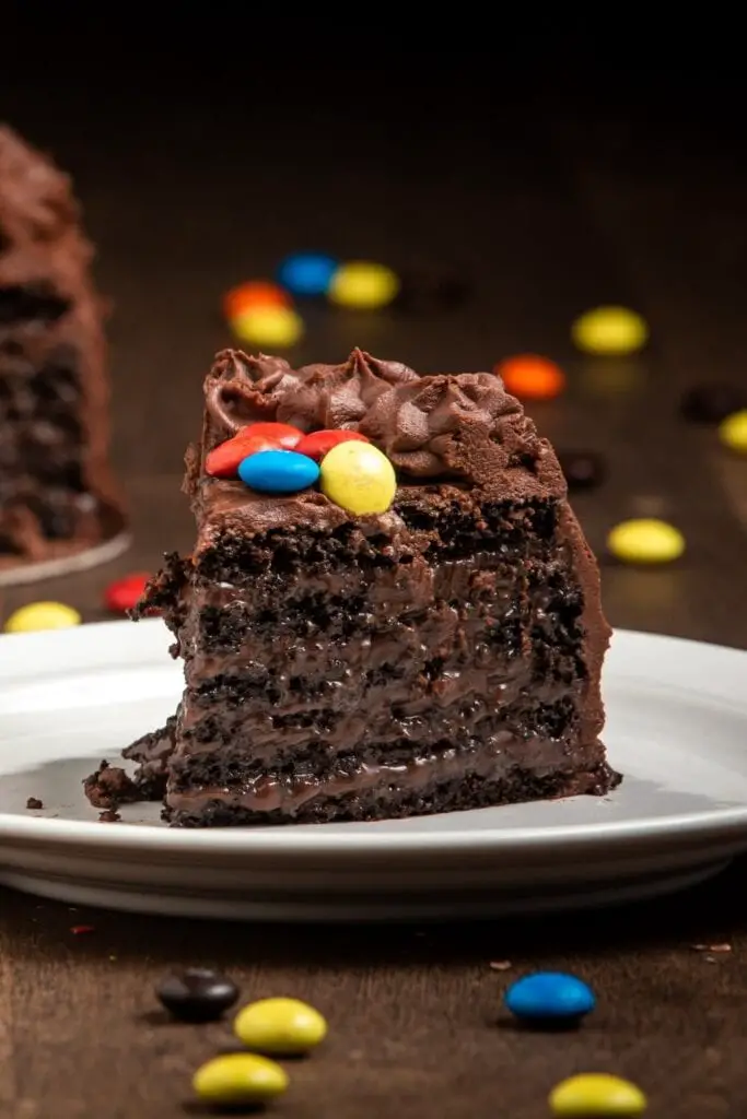 एम एंड एम की कैंडीज के साथ चॉकलेट केक का टुकड़ा