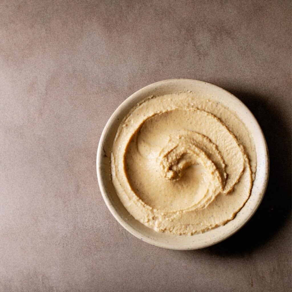Hummus en un plato marrón pequeño