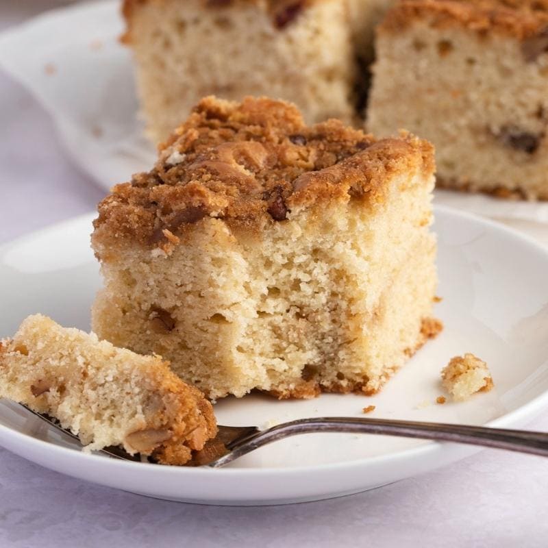 Fluffy coffee cake with sour cream served on a small white plate