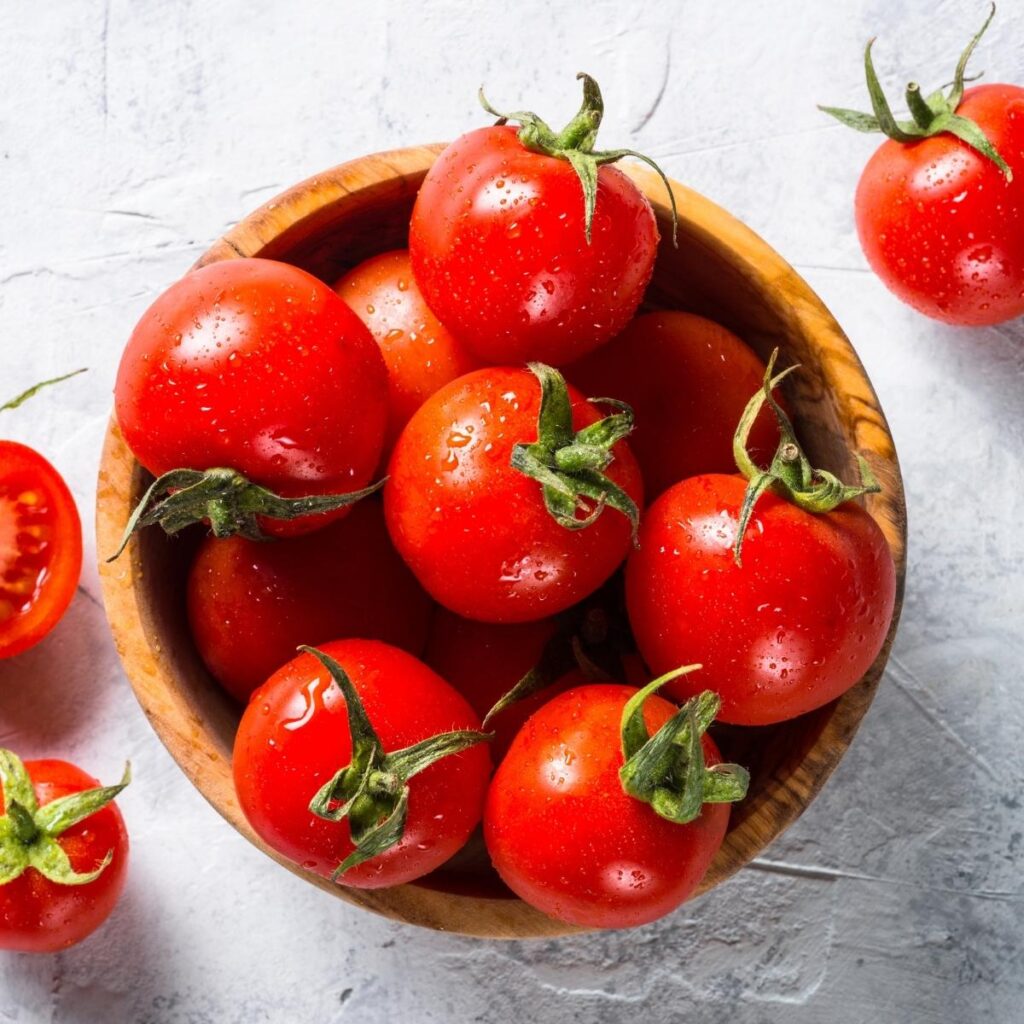 Tomatoes dearg organach amh ann am bobhla fiodha