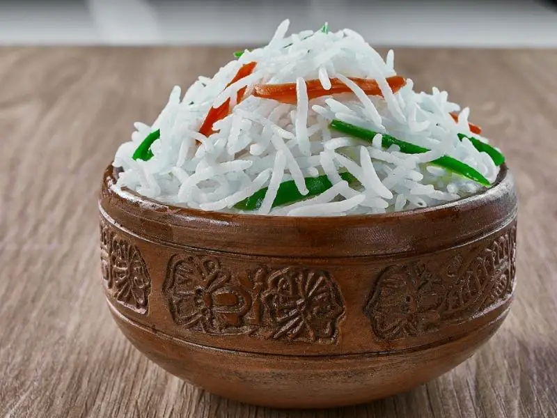 Basmati rice with bell pepper and carrot in a brown bowl