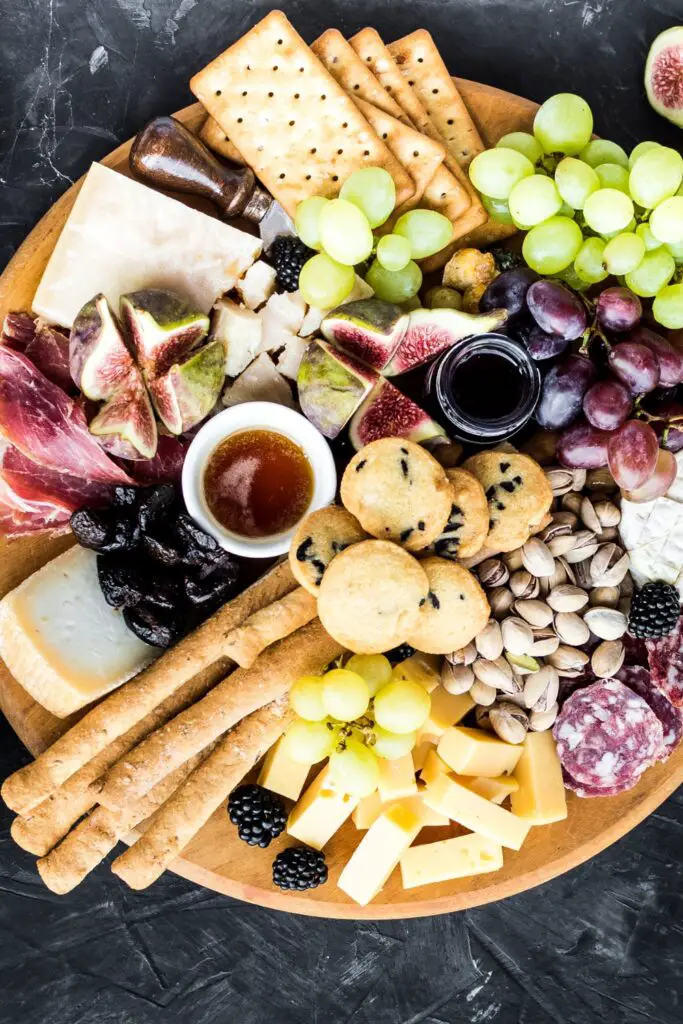 Апетизирана плоча за јело: пармезан, сир чедар, гауда, салама, воће и ораси