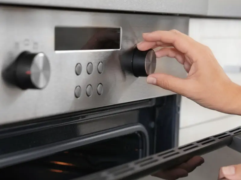 Abra o forno com a mão girando um botão