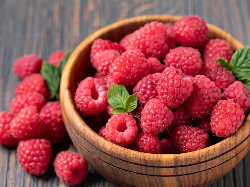 ໂຖປັດສະວະໄມ້ທີ່ເຕັມໄປດ້ວຍ raspberries