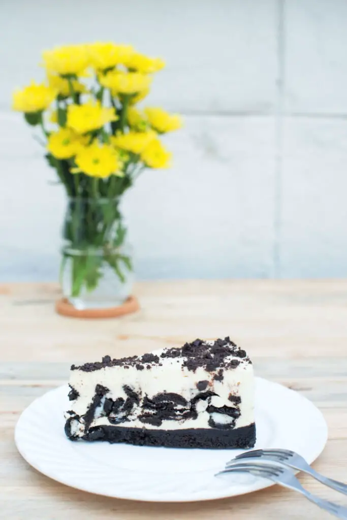 白盤上的費城奧利奧芝士蛋糕，背景是花瓶