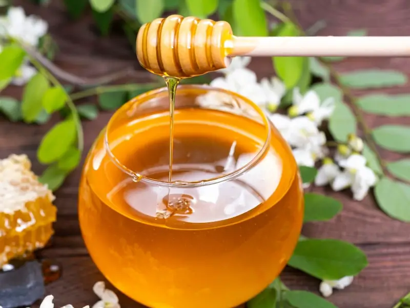 Akátový med v průhledné skleněné nádobě