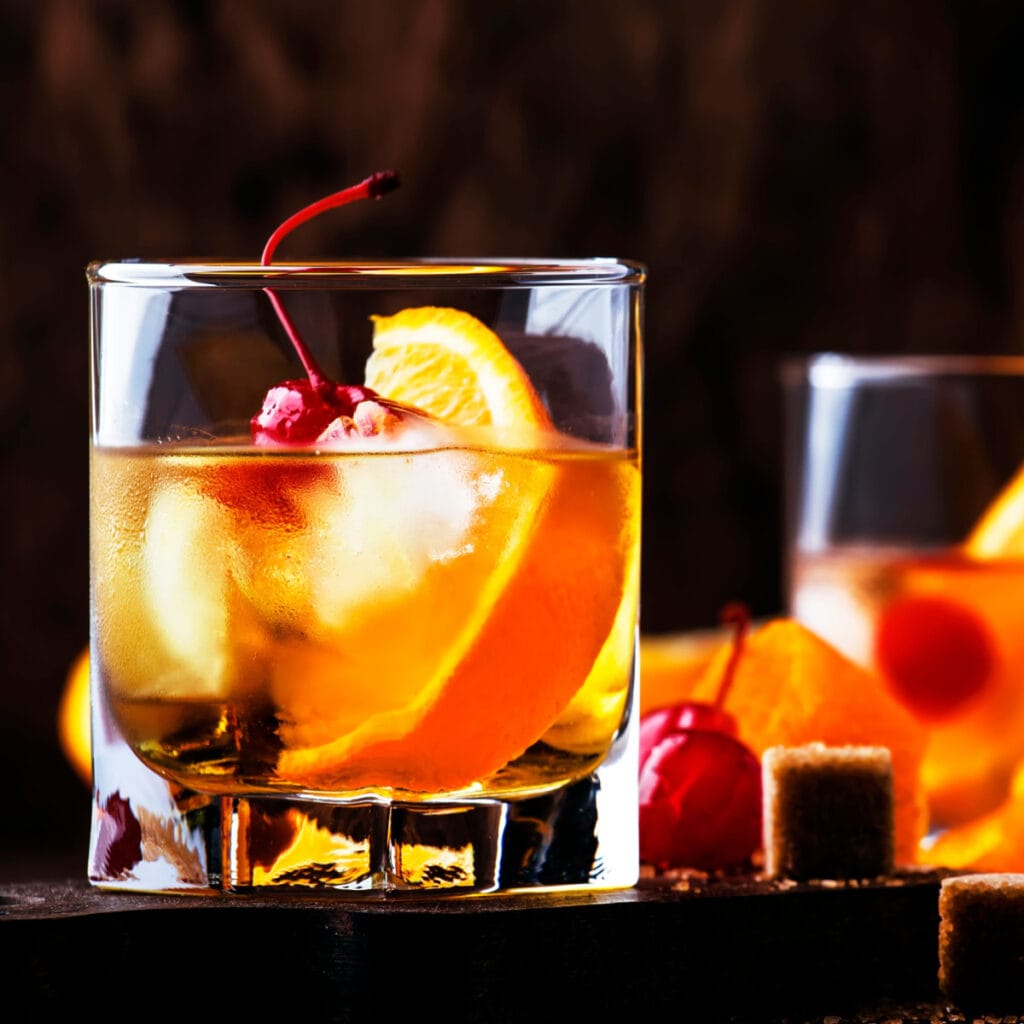 Zure cocktail met stukjes sinaasappel en verse kersen