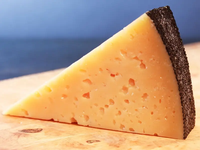 在木菜板上切成片的格鲁耶尔奶酪