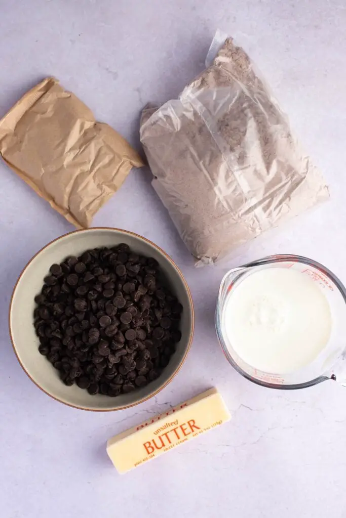 Ingredientes para pastel volcado de chocolate: mezcla para pastel de chocolate, mezcla para pudín seco, leche entera, mantequilla y chispas de chocolate