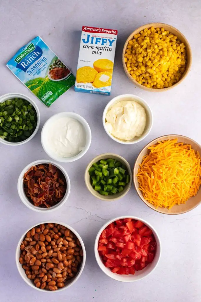 Ingredientes de la ensalada de pan de maíz: aderezo, pan de maíz, queso cheddar, tiras de tocino y vegetales