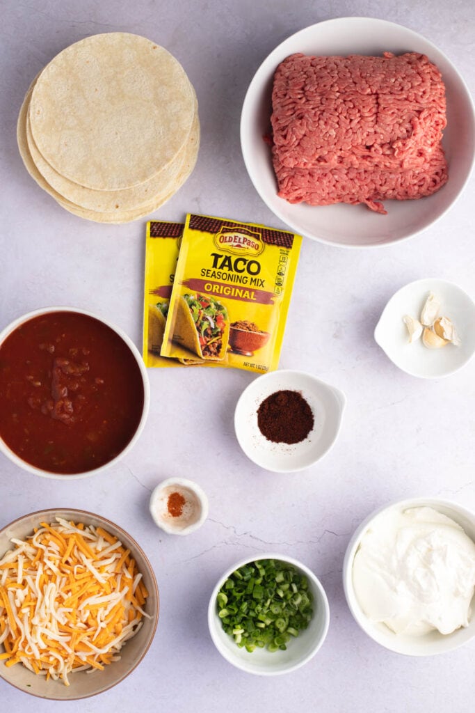 Ingredientes de lasaña de taco: vegetales, crema agria, condimentos, carne molida, queso, tortillas y salsa