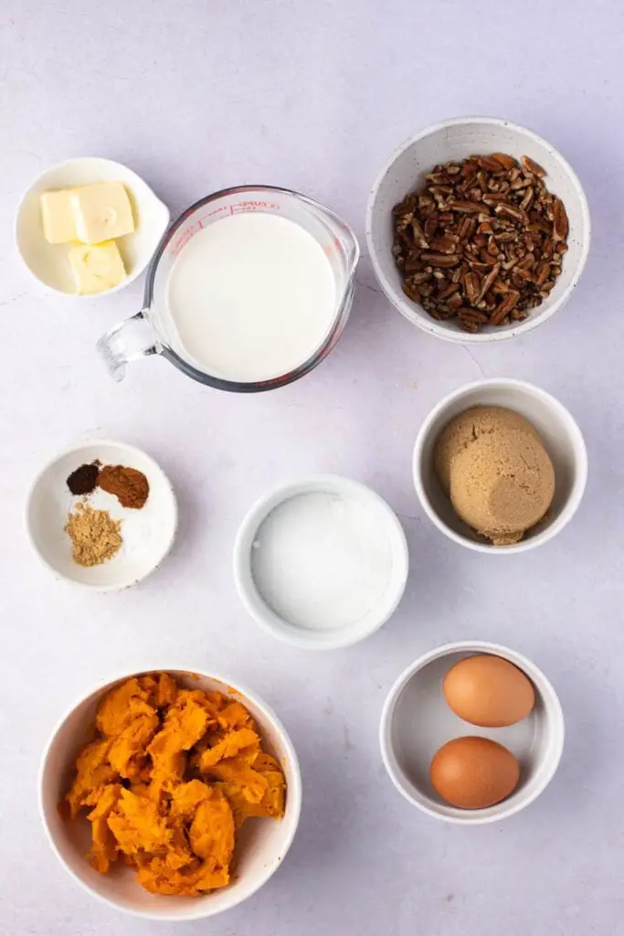 Ингредиенты для пирога со сладким картофелем и пеканом: тесто для пирога, сладкий картофель, яйца, соль, легкие сливки, орехи пекан и сахар.