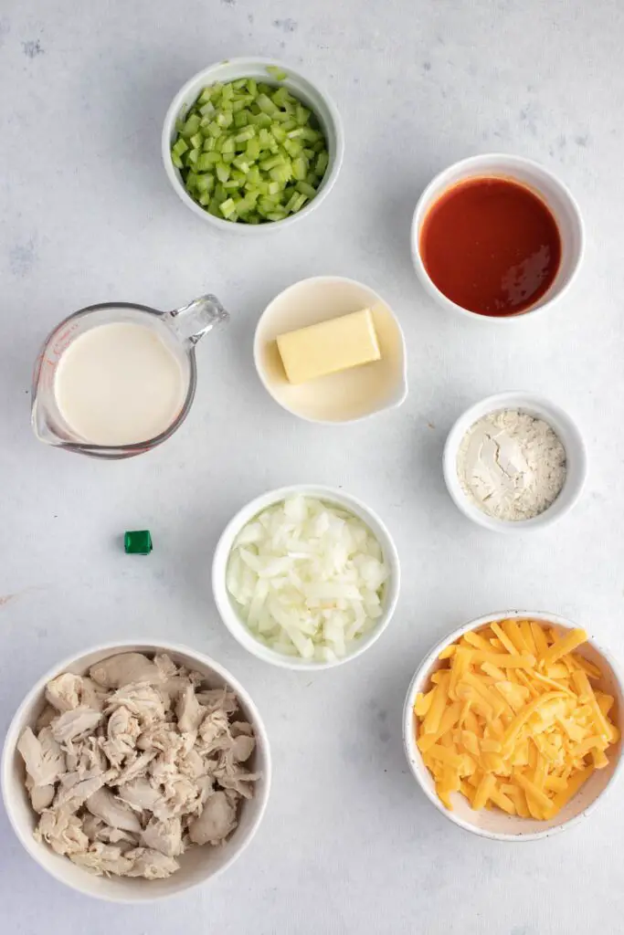 Ingredientes de la sopa de pollo al búfalo: mantequilla, verduras, harina, mitad y mitad y agua, pollo en cubos, salsa de alitas de pollo, queso cheddar, caldo de pollo, sal y pimienta