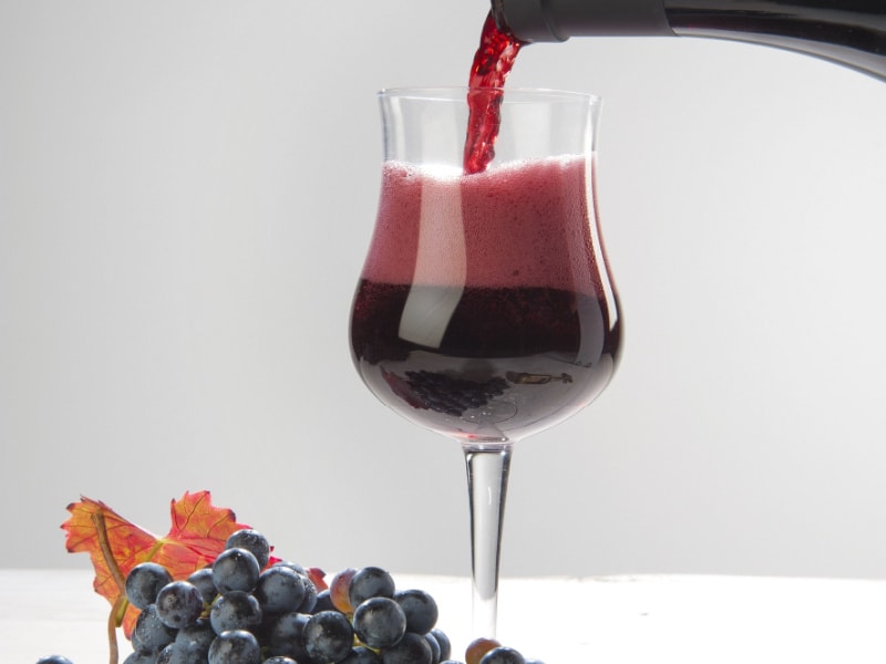Un racimo de uvas y una botella de vino Lambrusco
