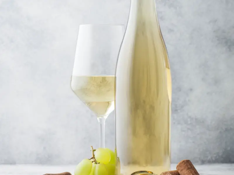Una botella y una copa de Chardonnay