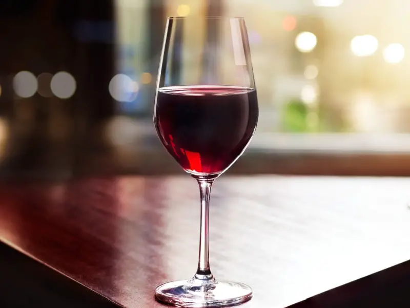 Una copa de tempranillo al borde de una mesa de madera