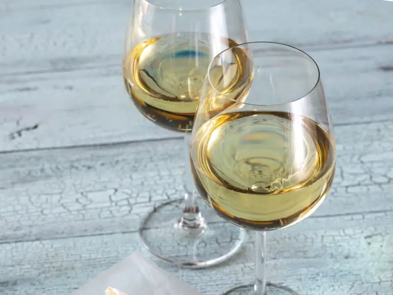 Dos copas de Sauvignon Blanc sobre una mesa de madera