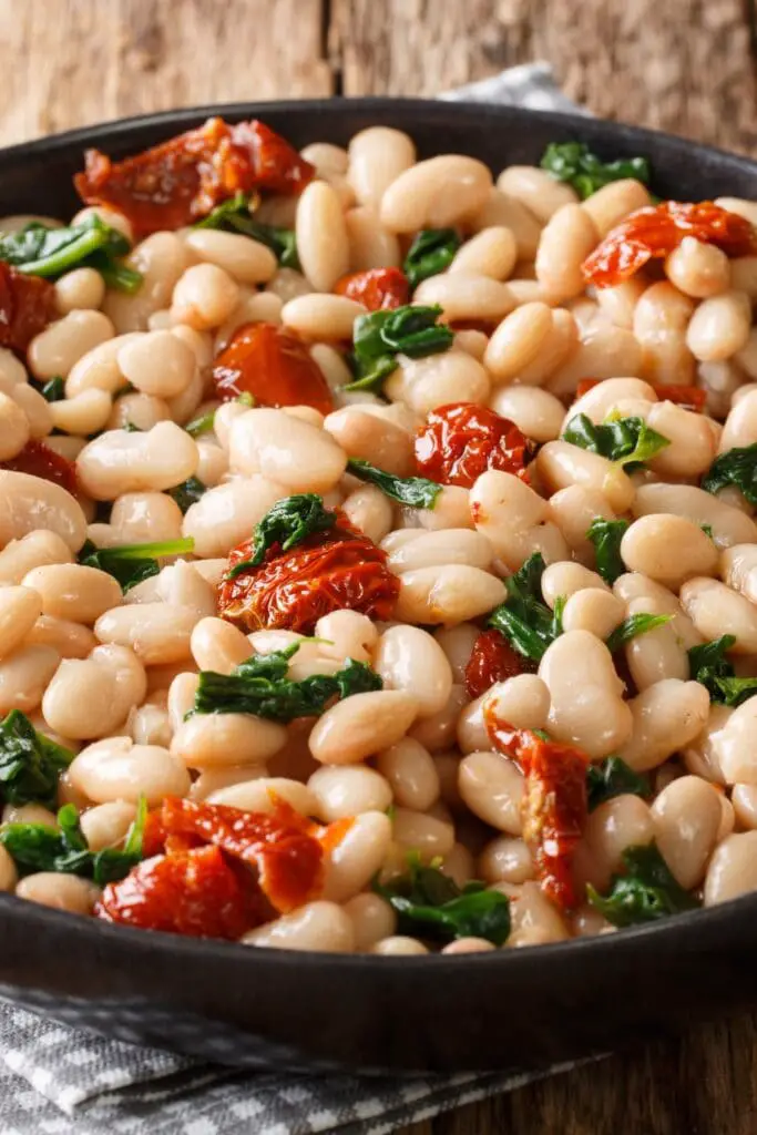 Frijoles cocidos caseros con ajo, espinacas y tomates