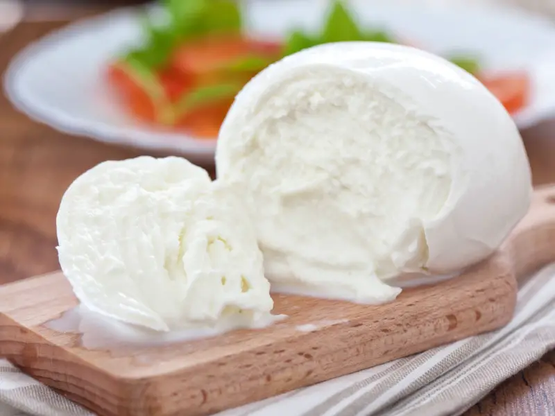 Queso mozzarella en una tabla de cortar de madera