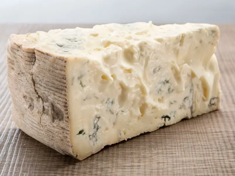 Una loncha de queso Gorgonzola sobre una mesa de madera