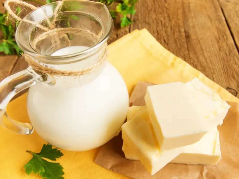 Una jarra de leche y rebanadas de mantequilla