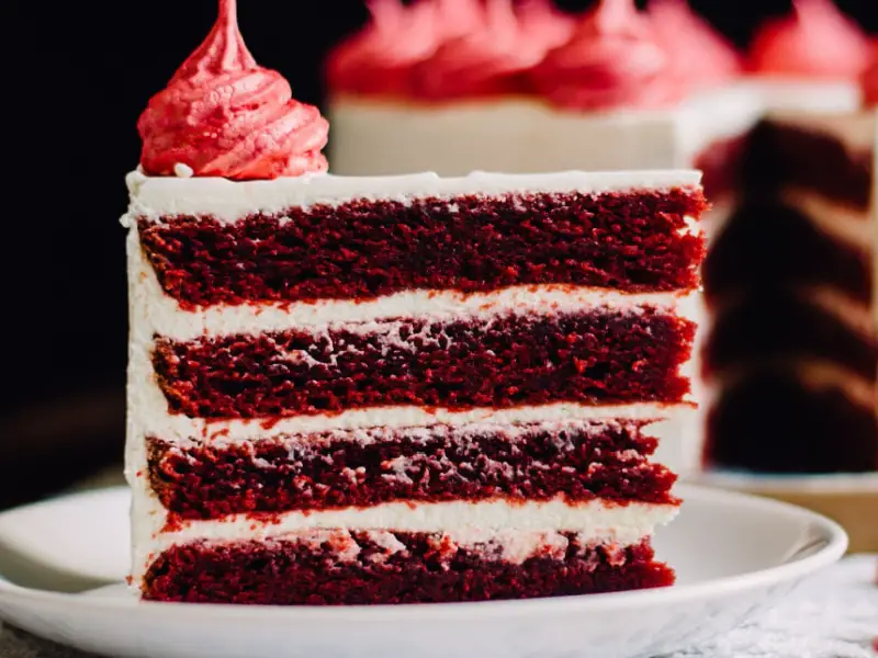 Una rebanada de pastel de terciopelo rojo con glaseado en la parte superior