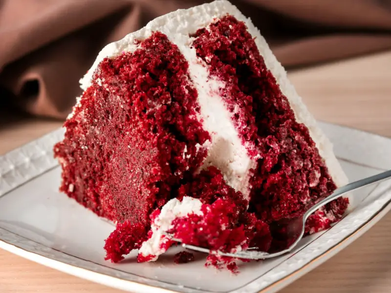 Una rebanada de pastel de terciopelo rojo en un platillo