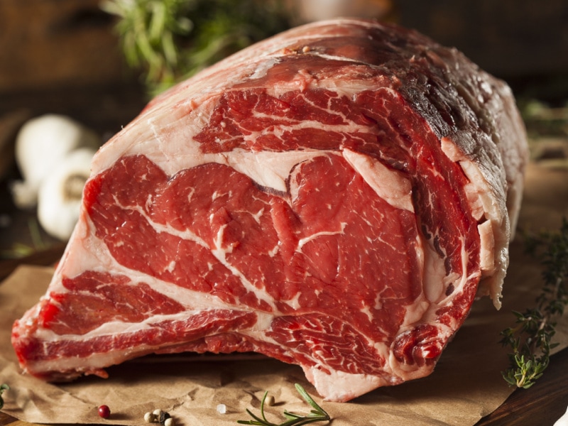 Syrové kousky rib eye steaku s bylinkami a kořením na pergamenu