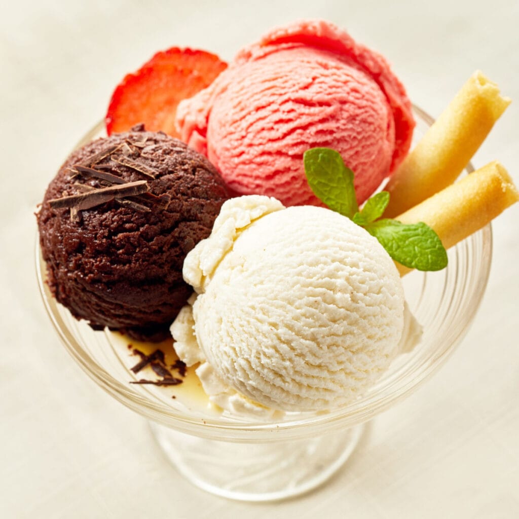Tres bolas de diferentes sabores de helado en un vaso