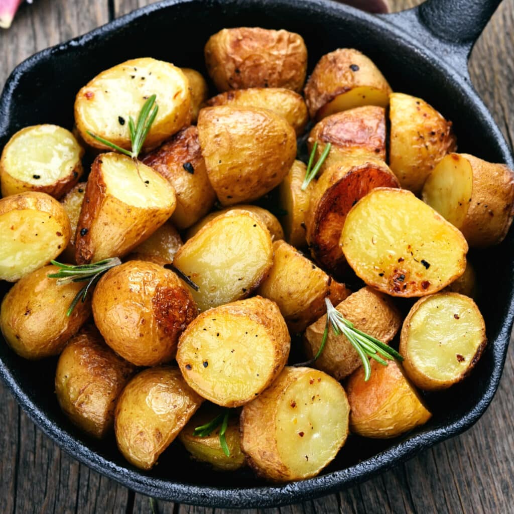 Patatas asadas al romero adornadas con hojas frescas