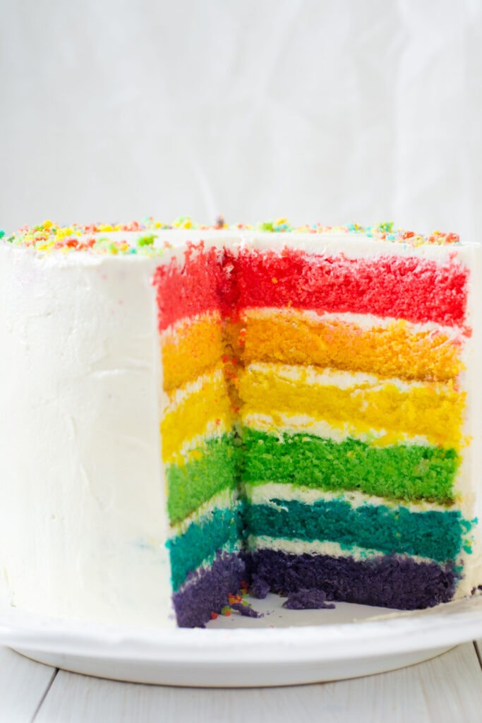 Kek pelangi bulat berwarna-warni yang dihiris