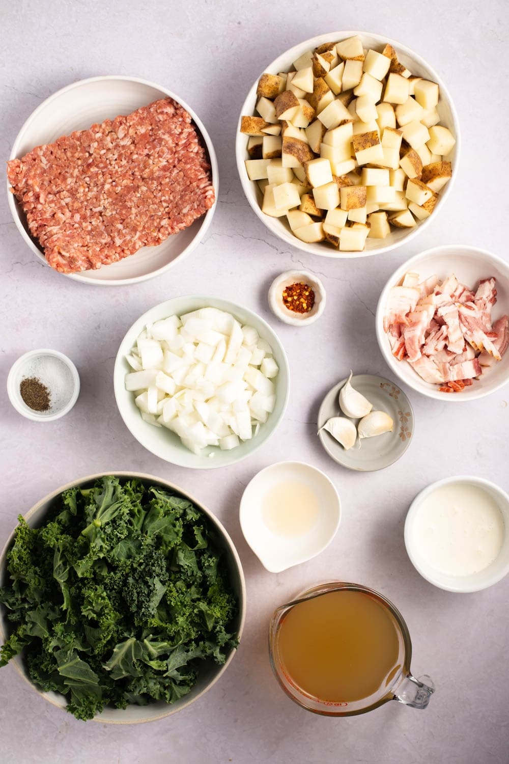 Ingredientes de la sopa Zuppa Toscana: salchicha italiana, tocino, papas, ajo, cebolla, caldo de pollo, col rizada y crema espesa