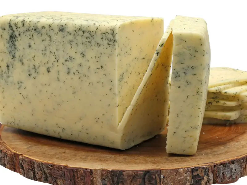 Piraso ng Havarti cheese sa isang kahoy na cutting board