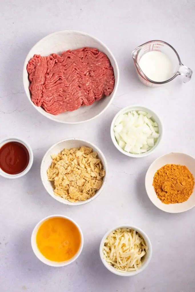 Ingredientes do Bolo de Carne Mexicano: Cebola, Tortilla Chips Trituradas, Queijo Pepper Jack, Taco Mix, Ovos, Leite e Molho de Tomate Vermelho