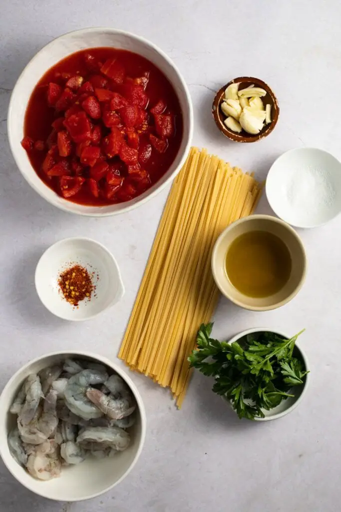 Ингредиенты соуса Фра Дьявло: оливковое масло, зубчики чеснока, помидоры, соль, измельченные хлопья красного перца, креветки и петрушка.