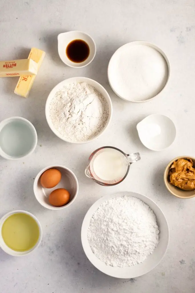 Peanøttsmørkake ingredienser: mel, hvitt sukker, natron, melk, egg, vaniljeekstrakt, vann, vegetabilsk olje, peanøttsmør og konditorsukker