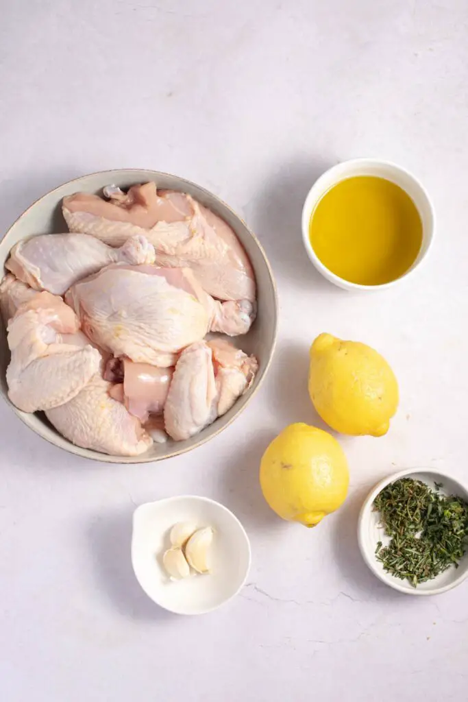 Bahan hayam Yunani: minyak zaitun, lemon, cengkéh bawang bodas sareng bumbu seger